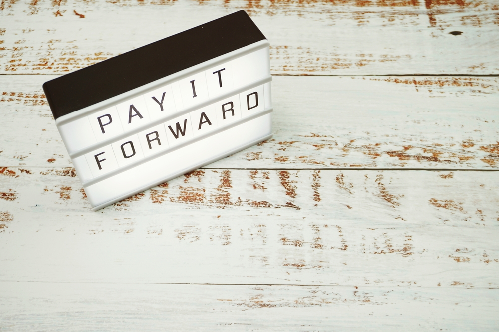 Pay It Forward spelled out on light box.