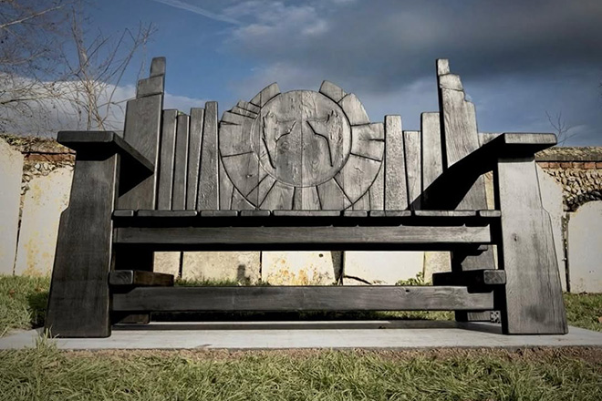 The devil horn shaped memorial bench dedicated to Keith Flint at St Mary's Church in Bocking, Essex, crafted from scorched black oak