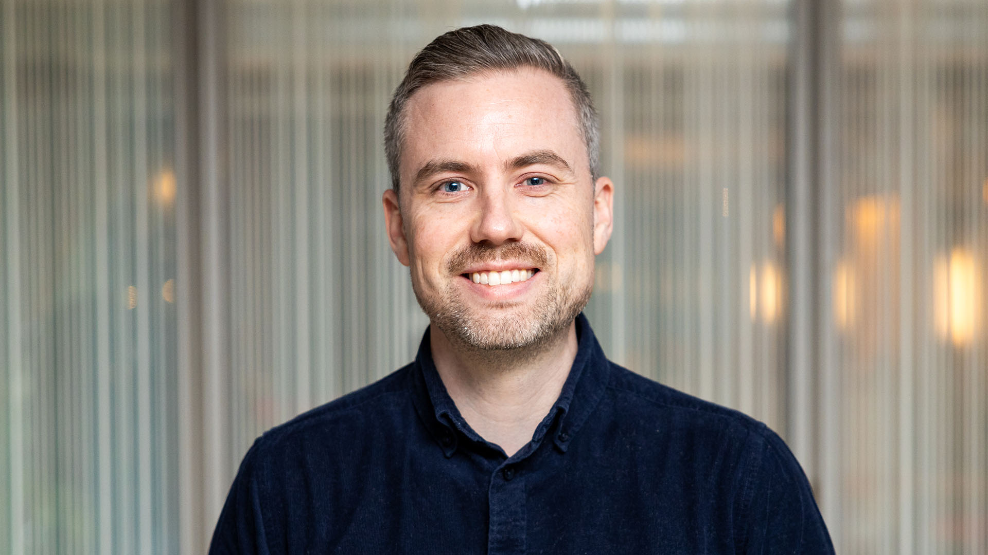 Foto. Mann ser inn i kamera og smiler