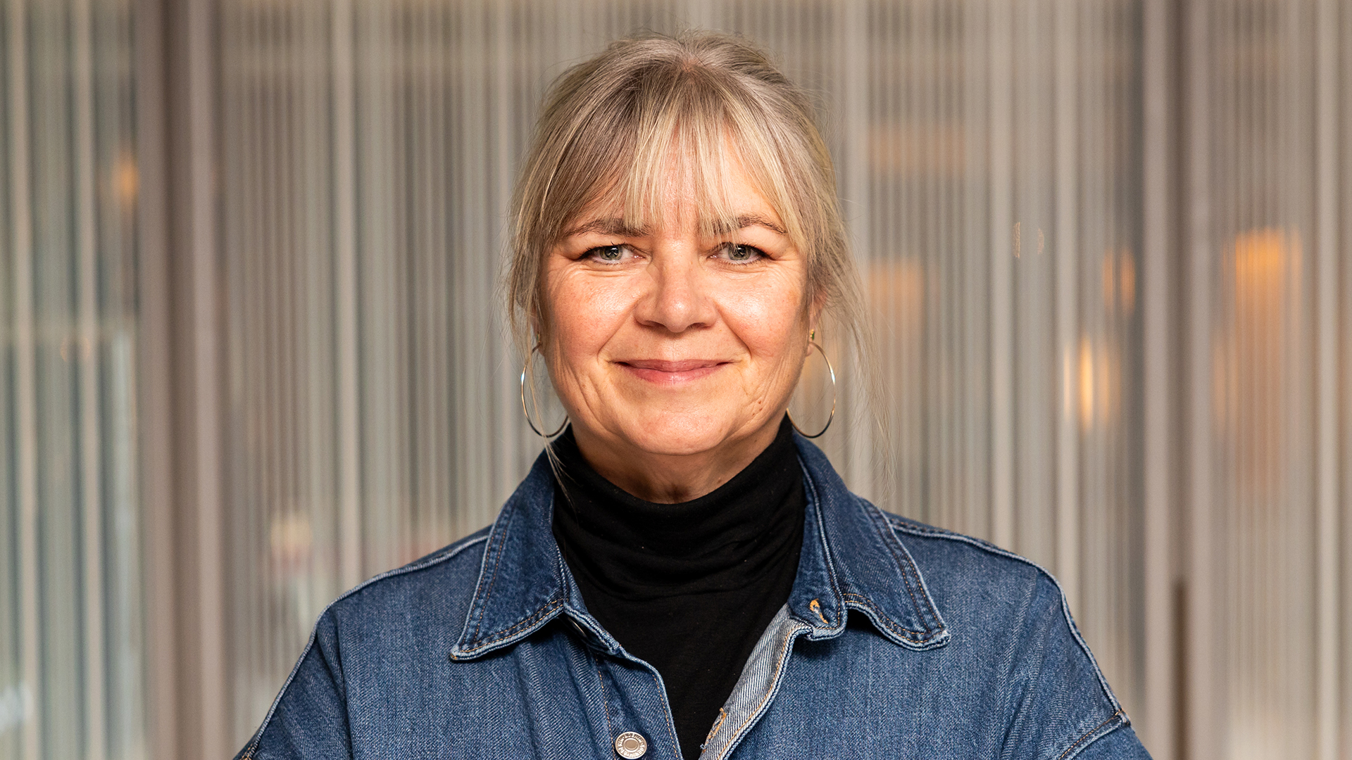 Foto. Kvinne ser inn i kamera og smiler.