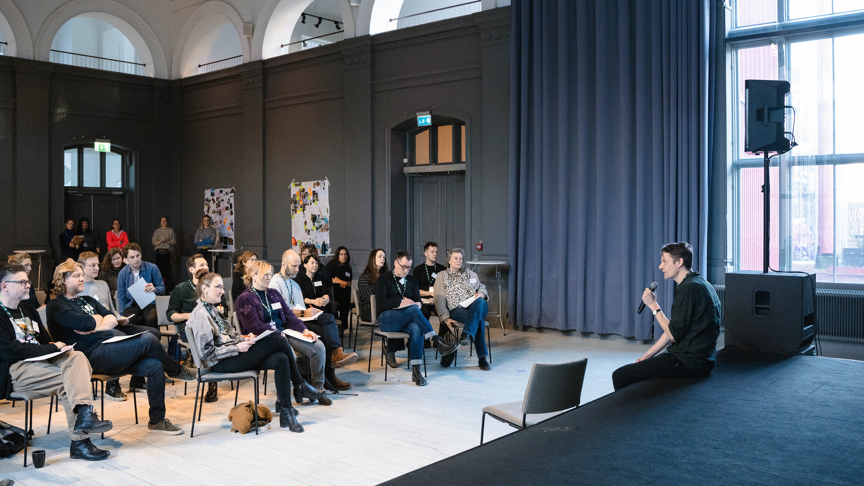 Foto. Mann holder tale foran lyttende forsamling