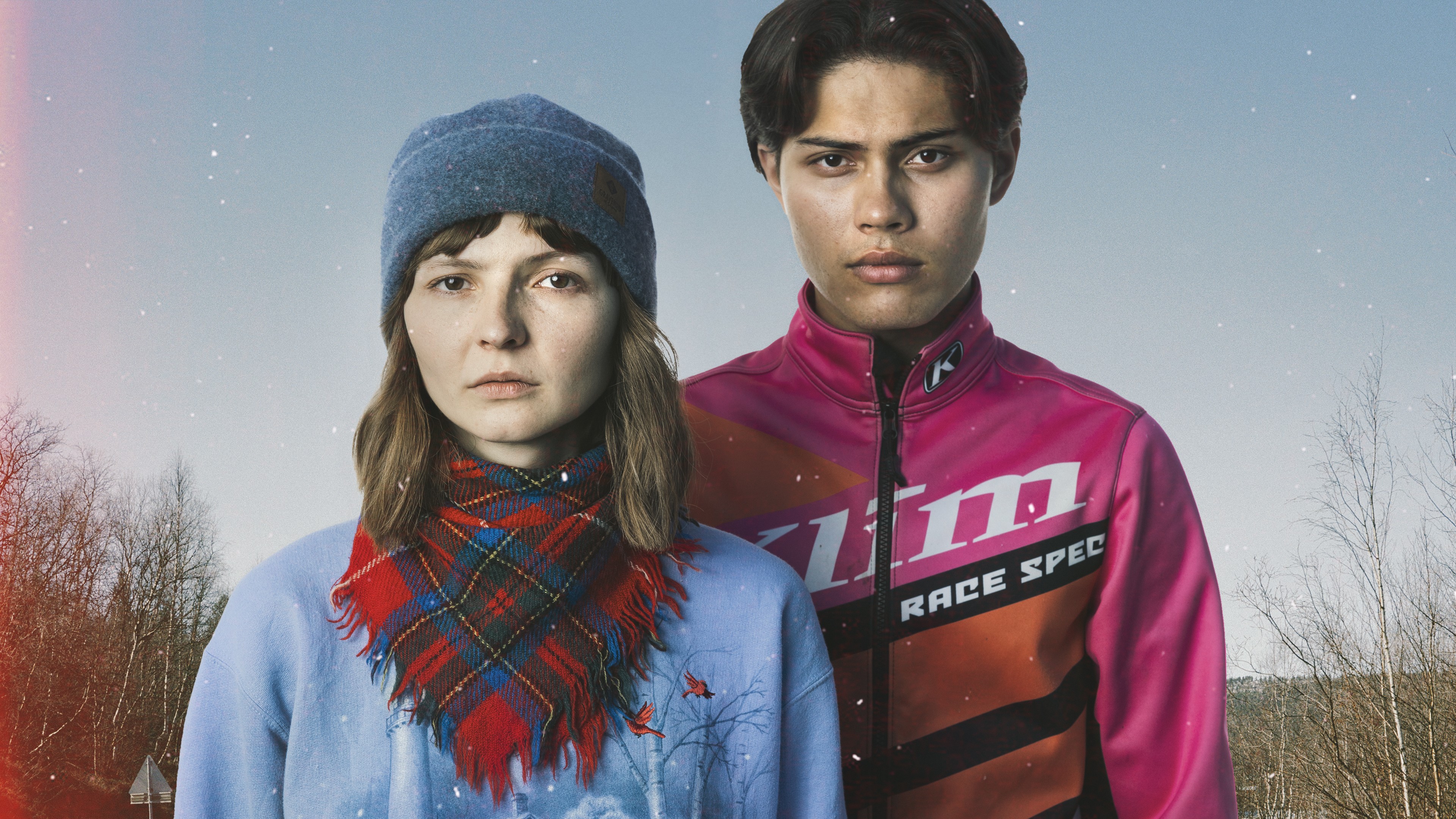 Teenage girl and boy looking into the camera, the girl wearing a Sami scarf.