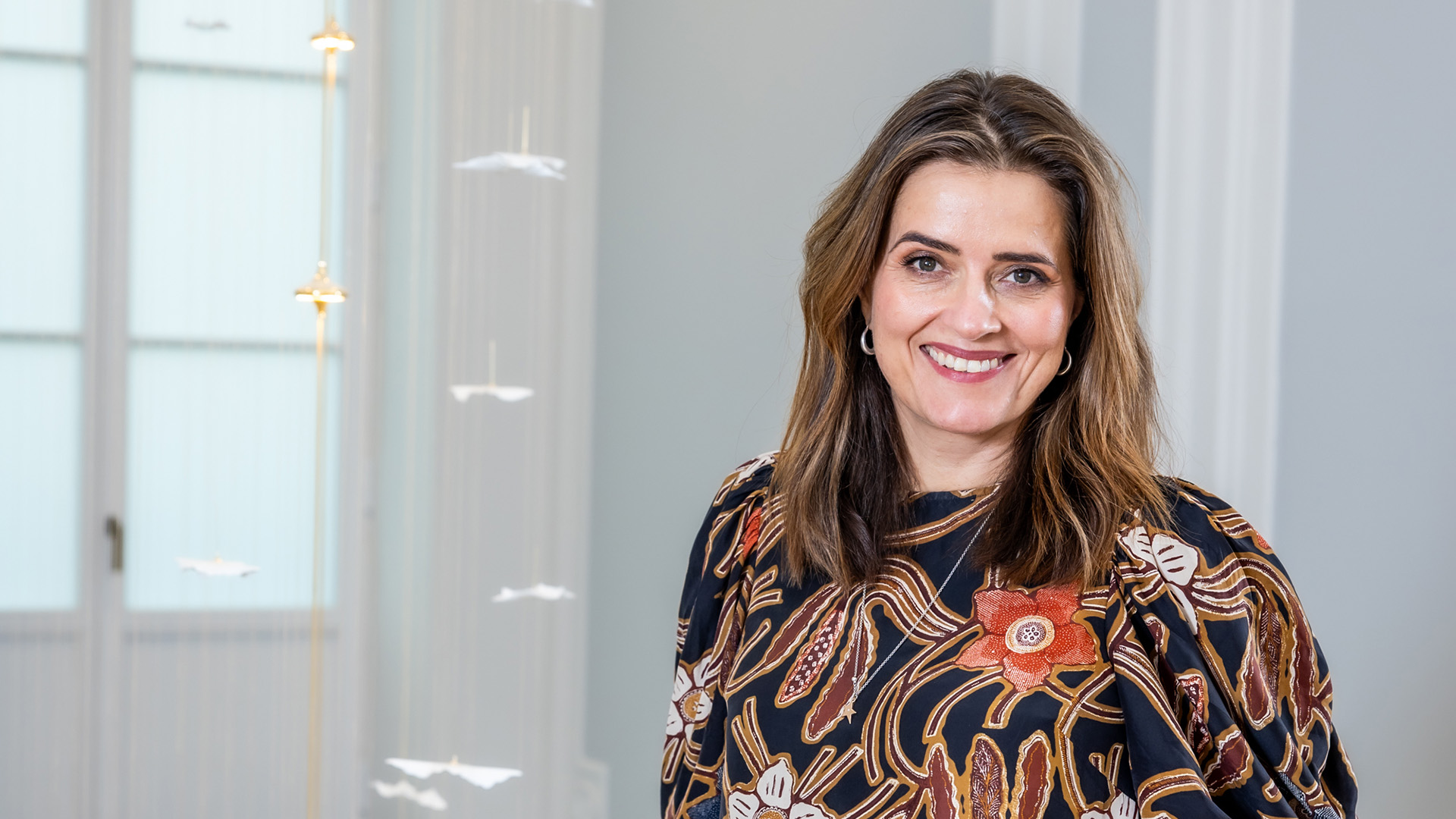 Foto. Kvinne ser mot kamera og smiler.