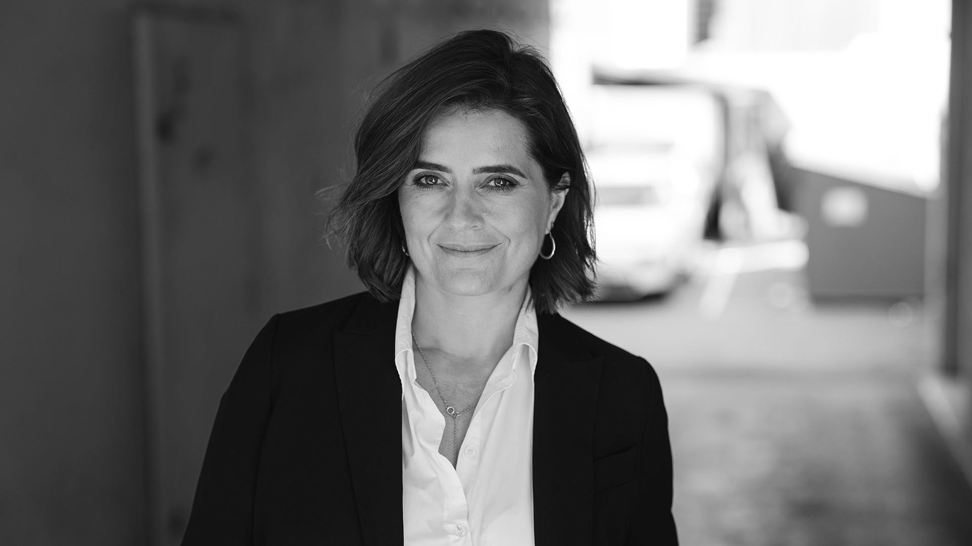 Foto. Kvinne ser mot kamera og smiler