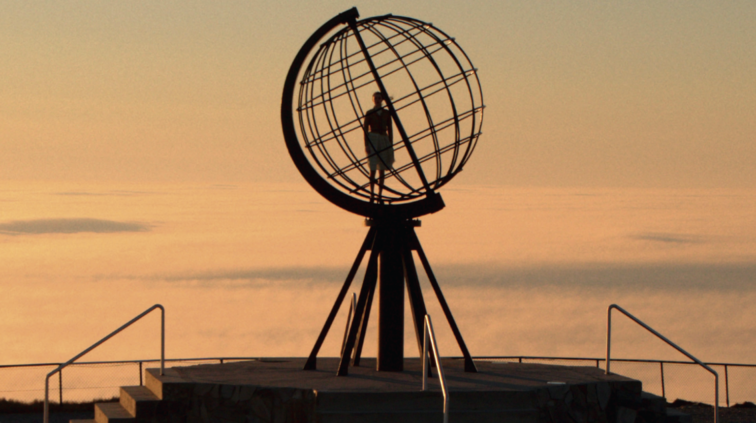 foto. nordkappmonumentet i silhouett med en person inni