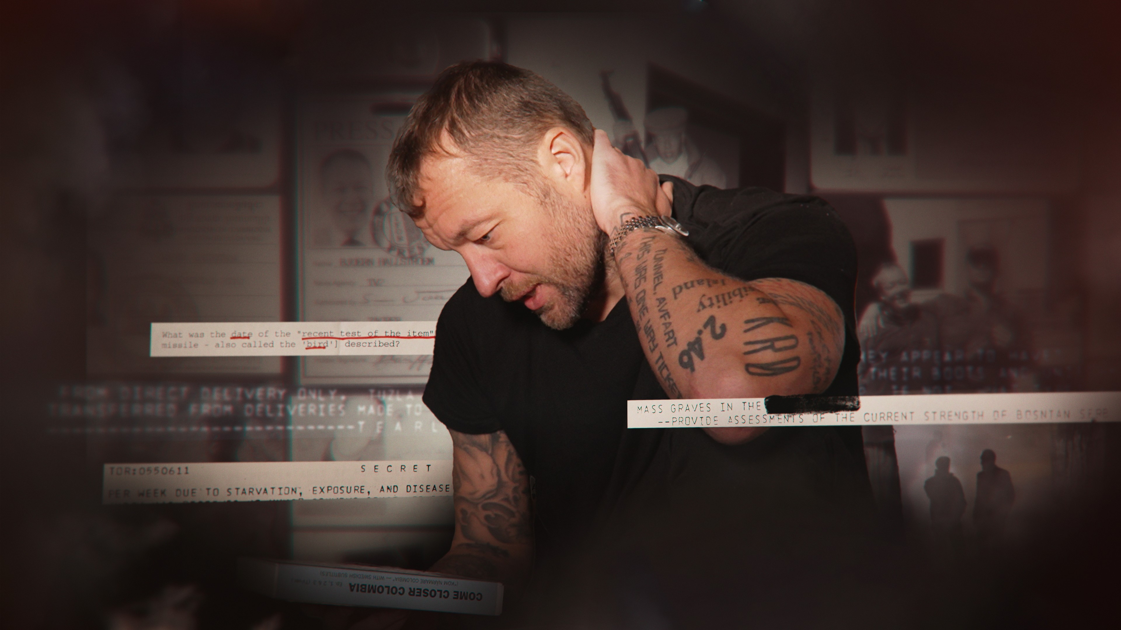 Foto. Mann med mange tatoveringer tar seg i nakken.