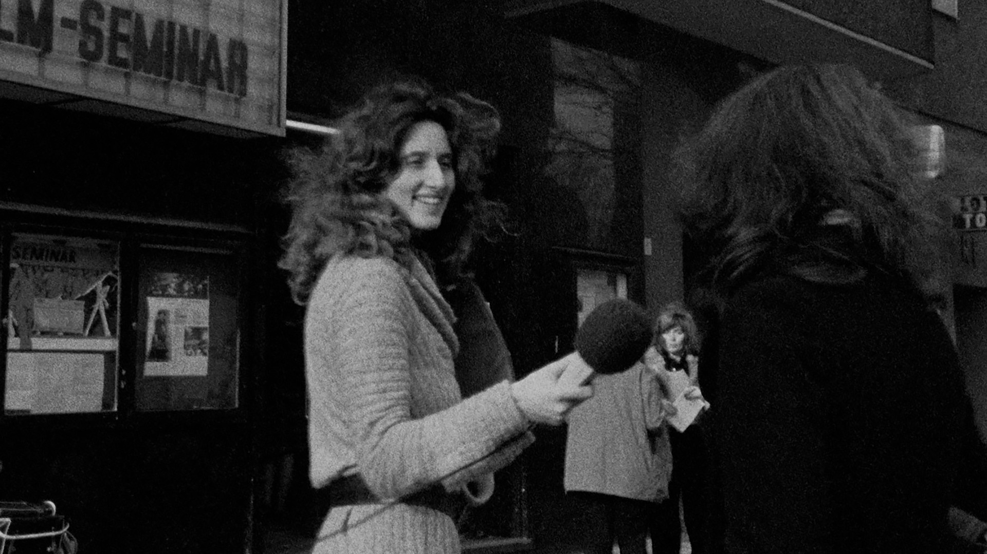 Foto. sort hvitt fotografi fra 70-tallet hvor en kvinne står med mikrofon og intervjuer en annen kvinne