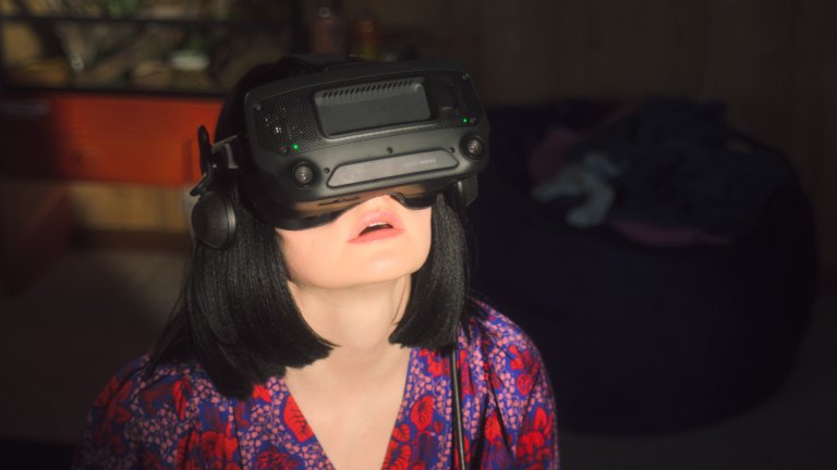 foto. kvinne med svart hår har på vr-briller og ser oppover.
