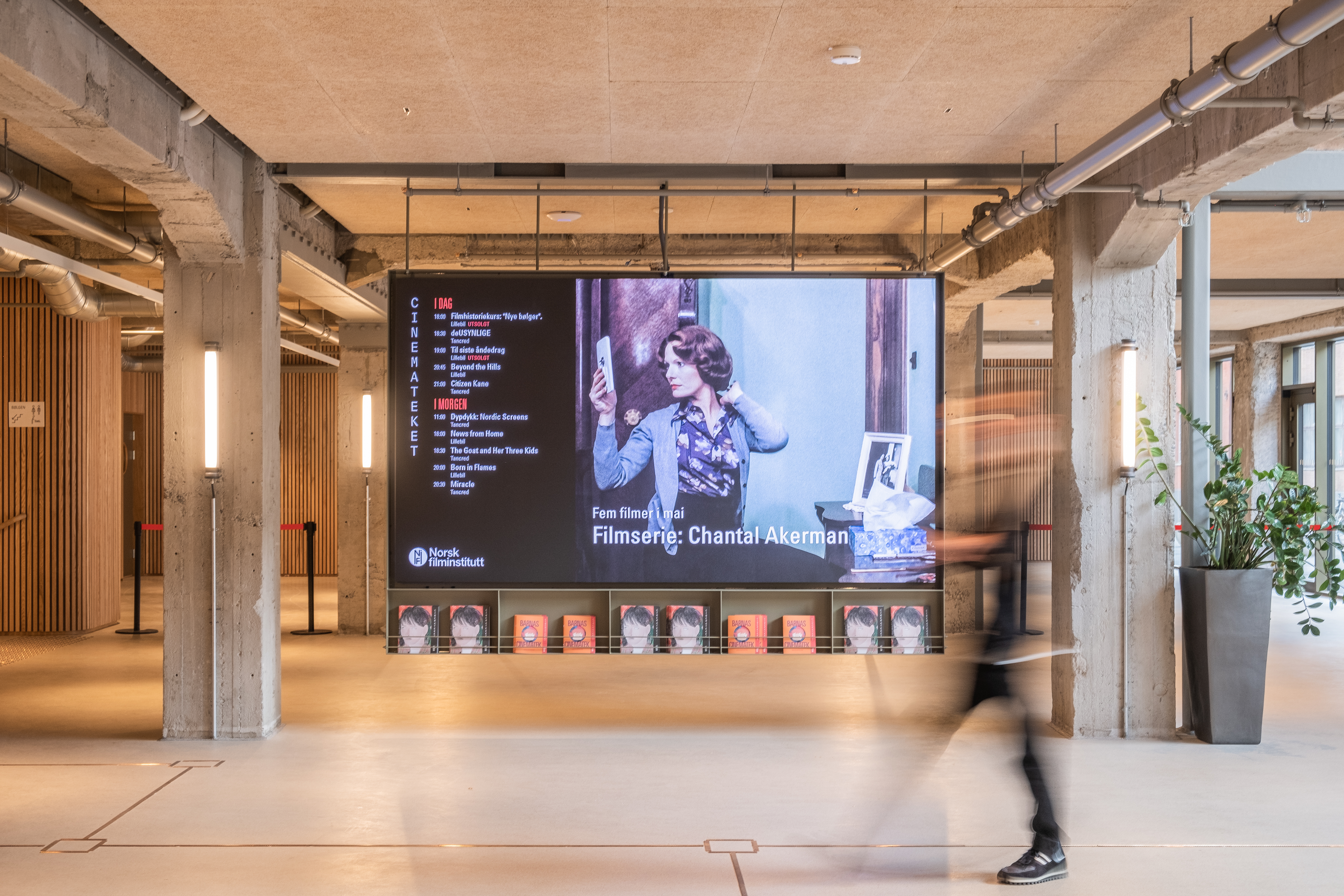 Foto. En stor LED-skjerm i et industrielt utseende område. Man ser konturene av et menneske som går forbi.