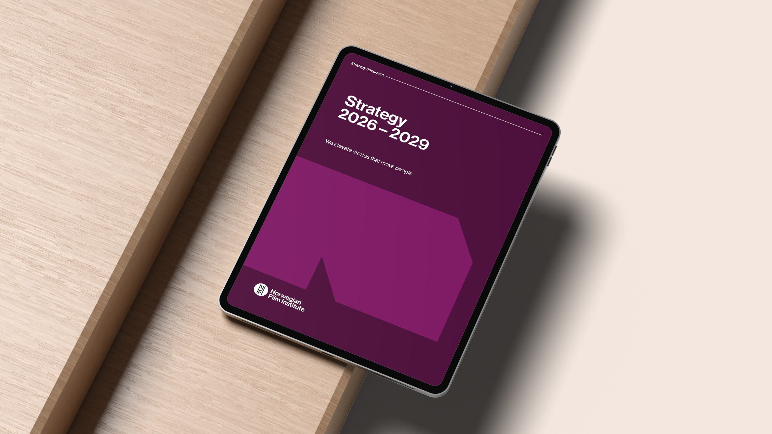 photo. ipad with the cover page of the Norwegian Film Institute strategy 2026-2029 in purple colors