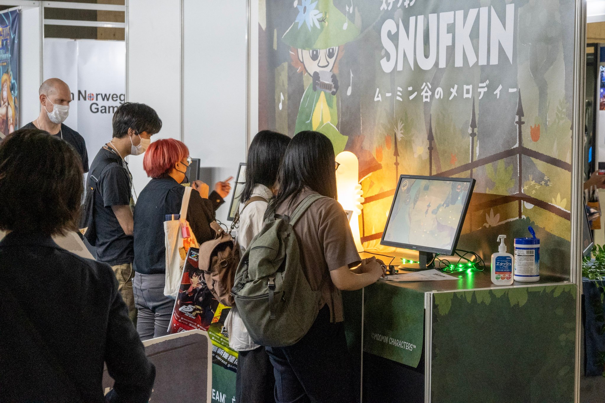 Foto. Mennesker som står på stand og tester spillet Snufkin på Tokyo Game Show i 2024.