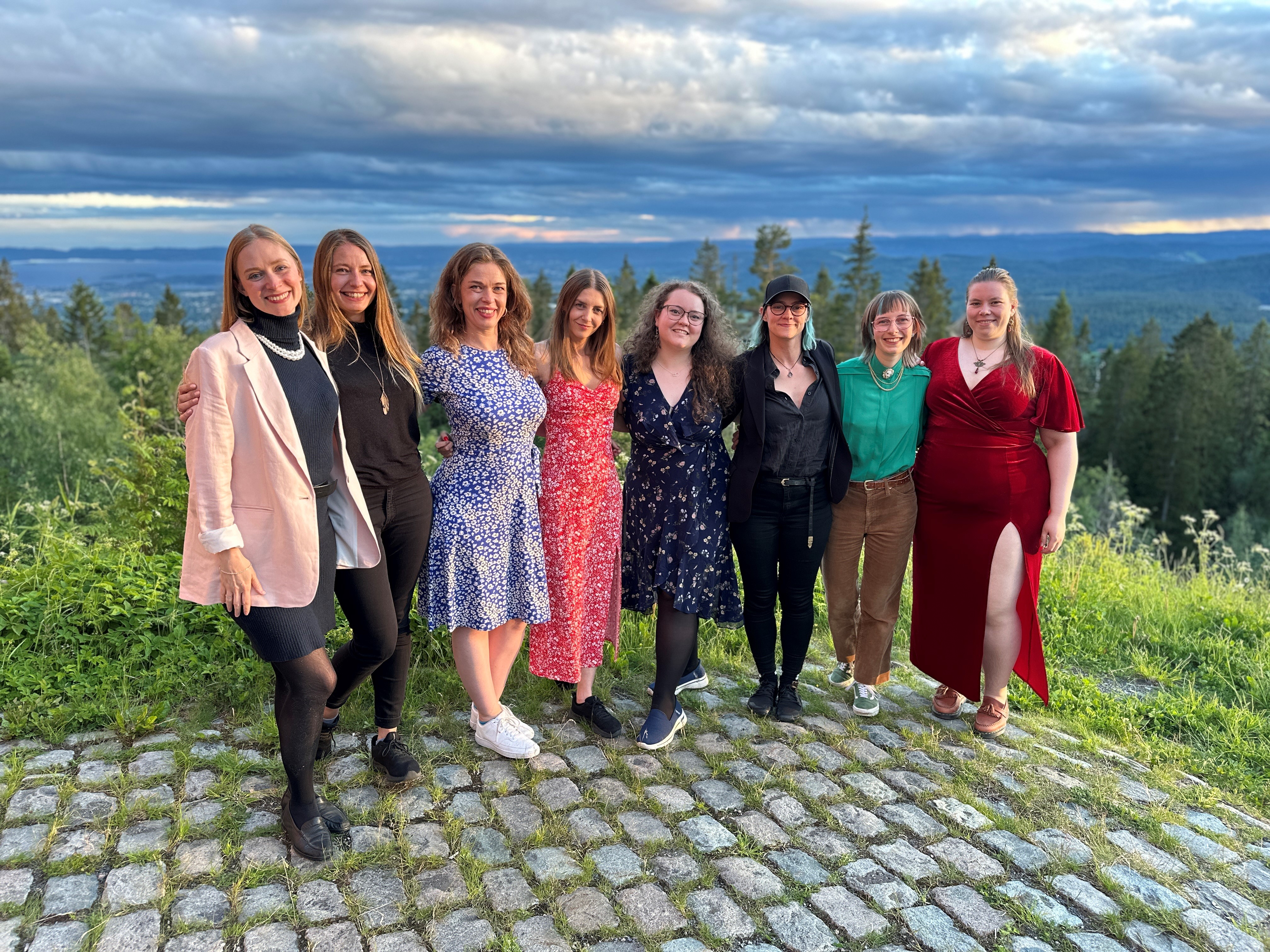 Foto. Åtte unge kvinner som smiler mot kameraet på Voksenkollen i Oslo hvor de er på Up3 samling