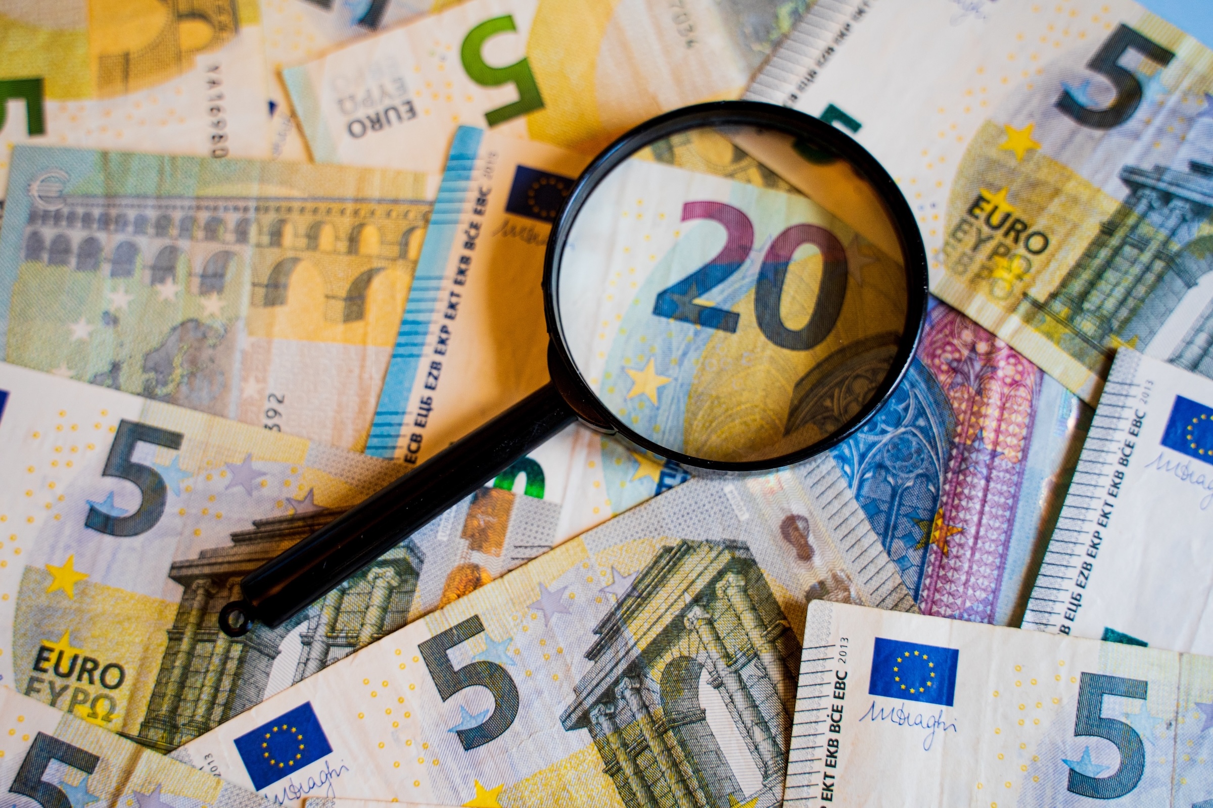 Euro notes under magnifying glass