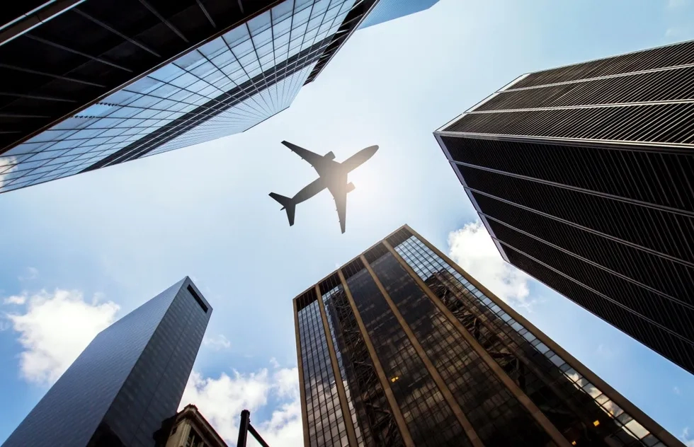 silhouette of airplane flying over buildings