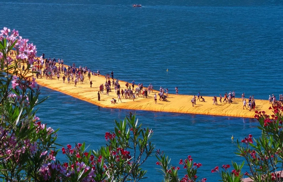 Tourists walk along "The Floating Piers," a temporary art installation on Lake Iseo in Northern Italy
