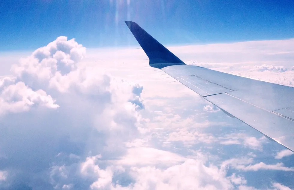 View from a plane's window seat, showing clouds and aircraft wing