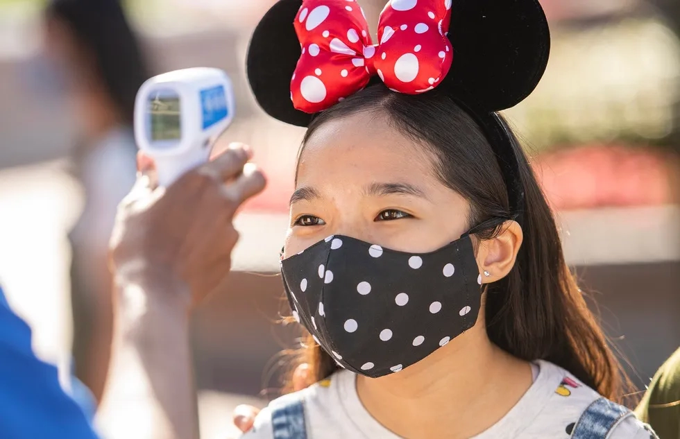 A masked guest gets a temperature screening at Walt Disney World Resort in Florida