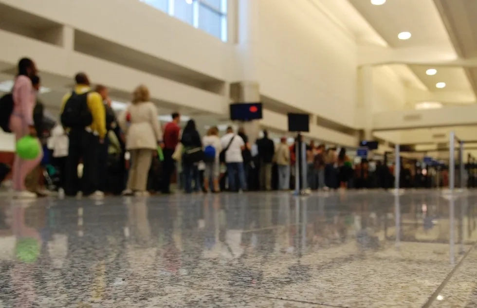 People wait in line to go through airport security