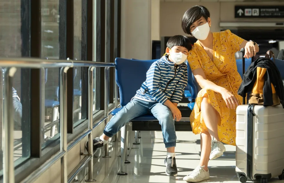 Masked woman and child at airport