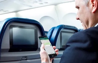 Businessman using smartphone on plane