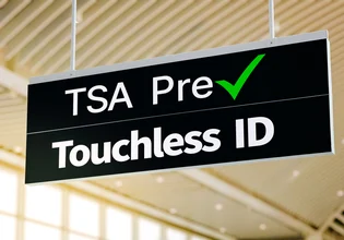 Airport terminal directional sign for TSA PreCheck Touchless ID indicating the new biometric facial recognition security lanes for fast boarding and identity verification.