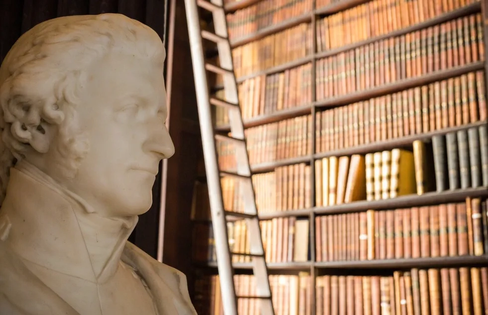 A marble bust and shelves of books inside the Long Room at Trinity College in Dublin