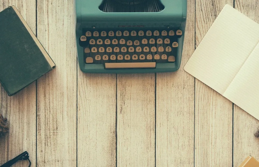 A typewriter and notebooks