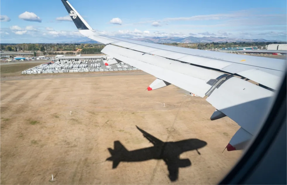 Air New Zealand flying over airport with shadow