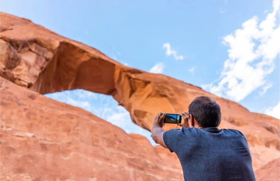 man takes photo of arch from beneath, Arches National Park, Utah