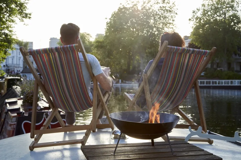 couple lounging on roof of London barge houseboat