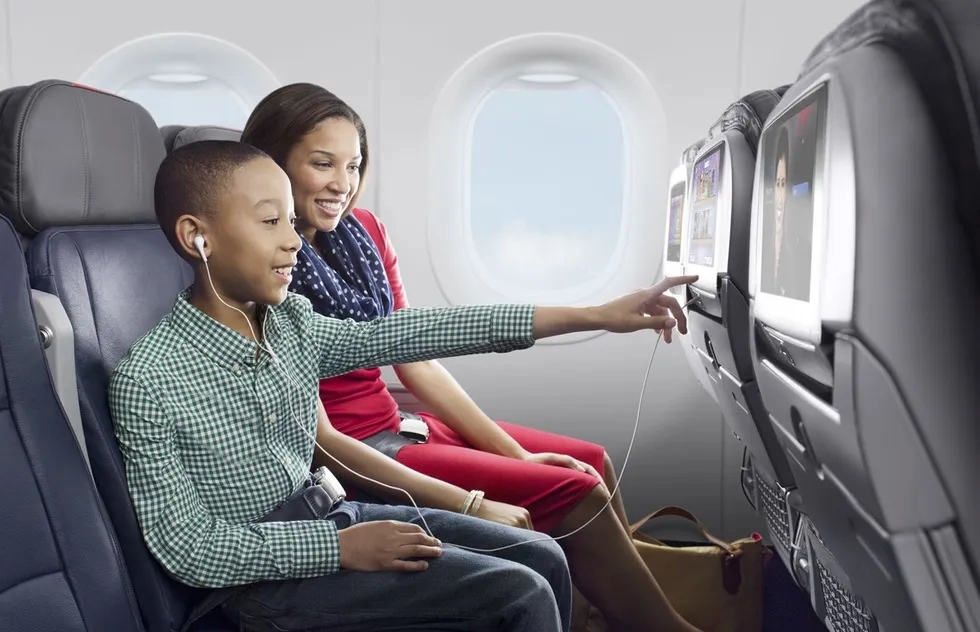 well-dressed child and mom touch screen in economy class on American Airlines