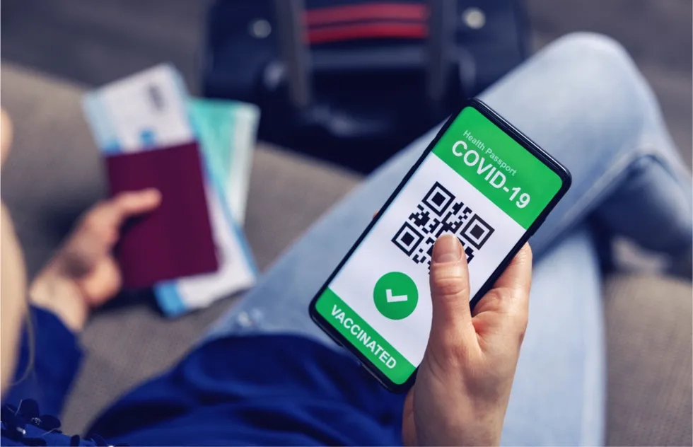 photo illustration: traveling person with Covid-19 vaccination qr code on phone