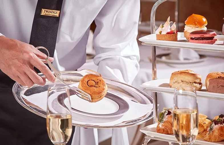 Waiter serving scone at afternoon tea on Cunard