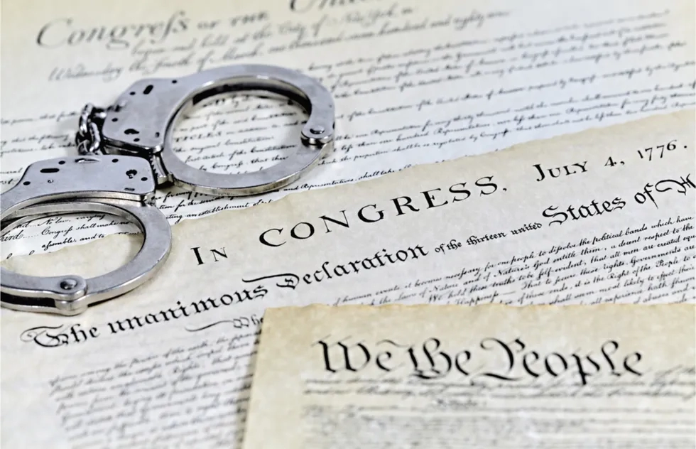 Declaration of Independence and Constitution with handcuffs (illustration)