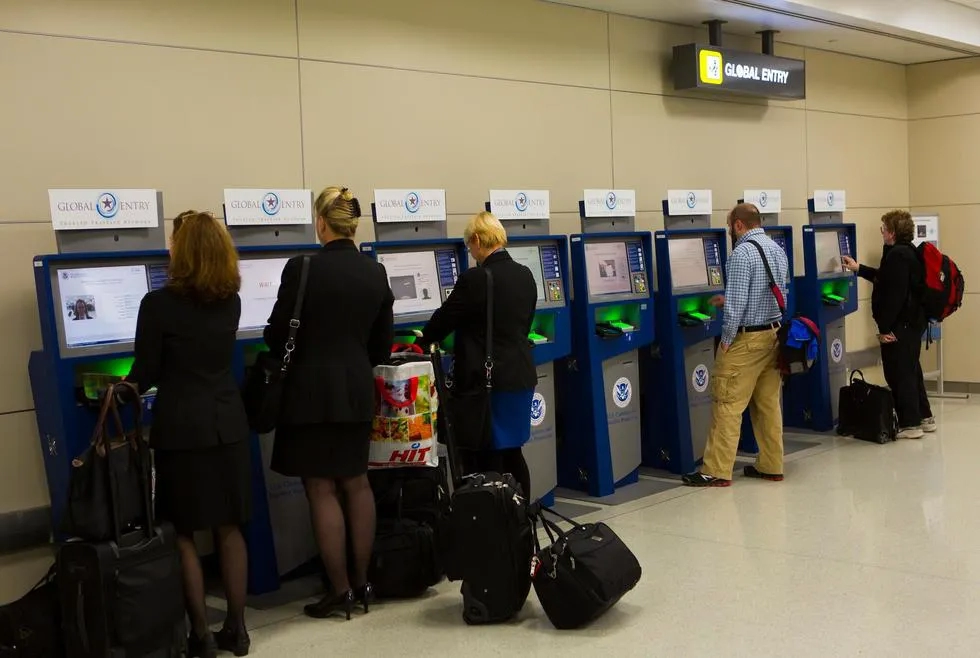 Travelers using Global Entry kiosks at the airport