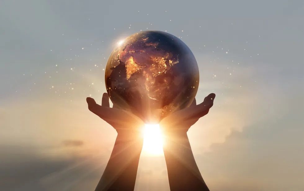 Hands holding glass earth (photo illustration)