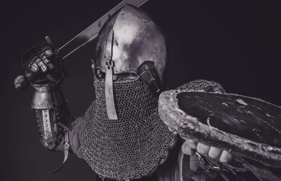 Knight in armor with sword and shield raised