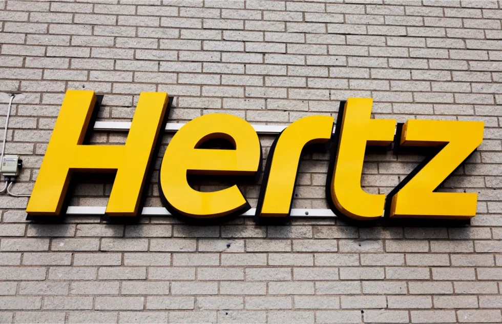 Hertz rental car sign on brick wall