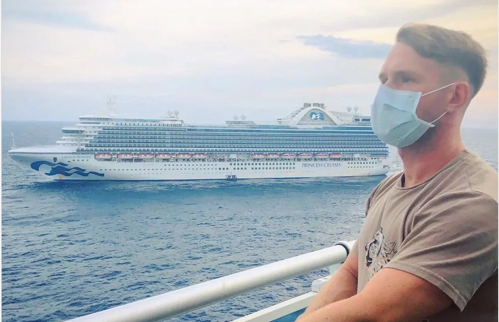 Crew member Jamey Grisham in mask on a Princess ship balcony