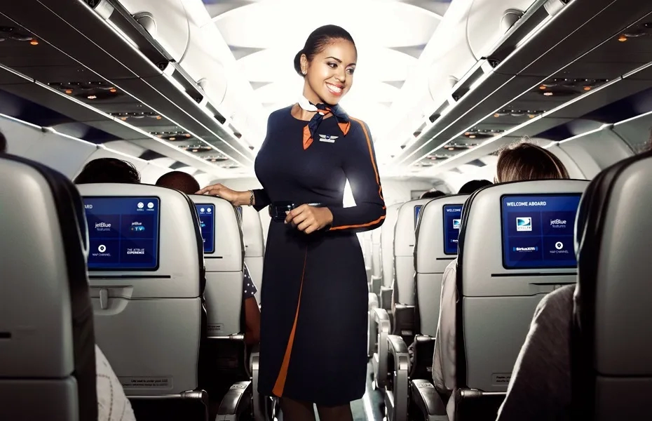 JetBlue flight attendant smiling in aisle