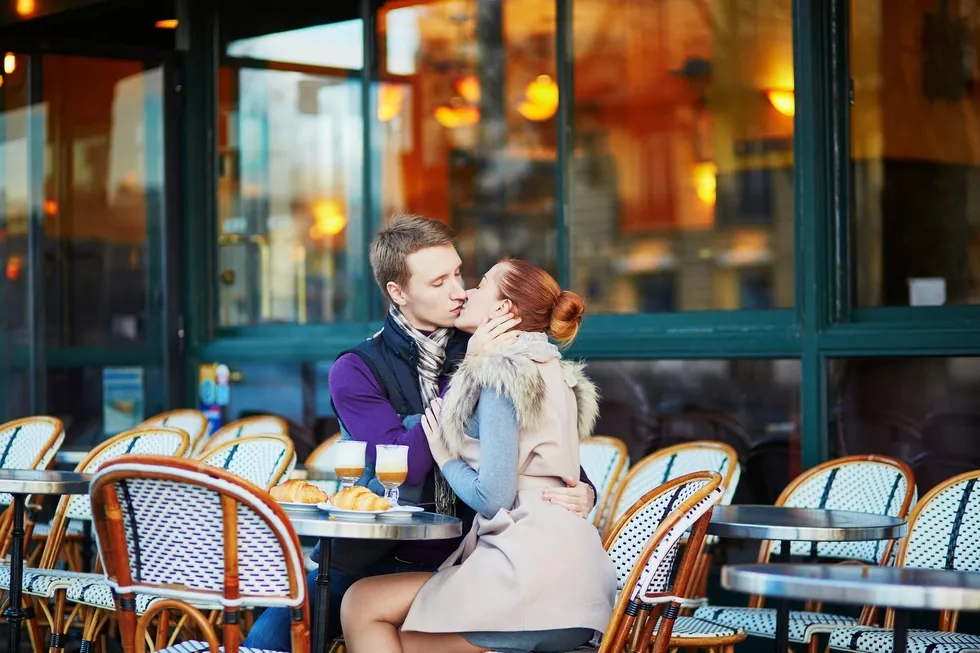 heterosexual lovers kiss at outdoor paris cafe