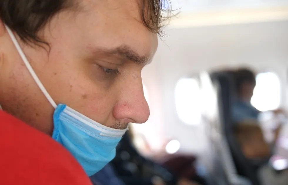 man wearing medical mask incorrectly during a flight