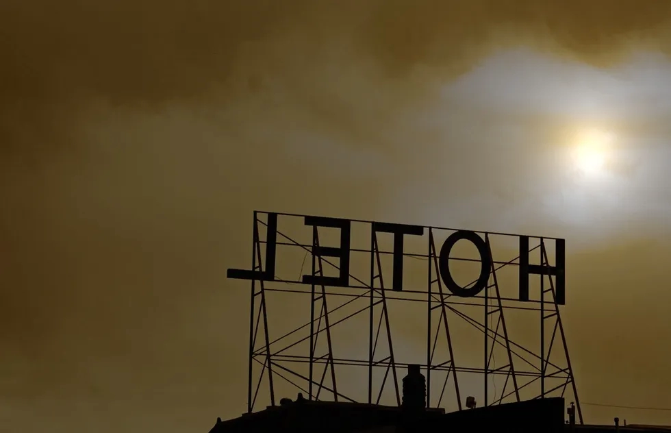 rooftop hotel sign in dark smoky sun haze
