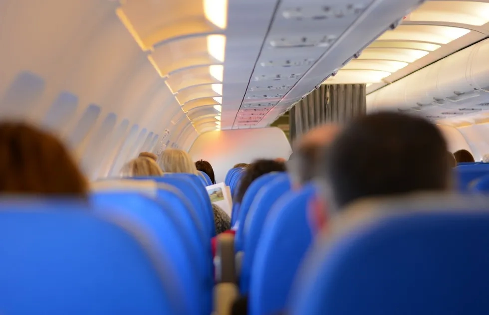 backs of passengers in seats on generic airline