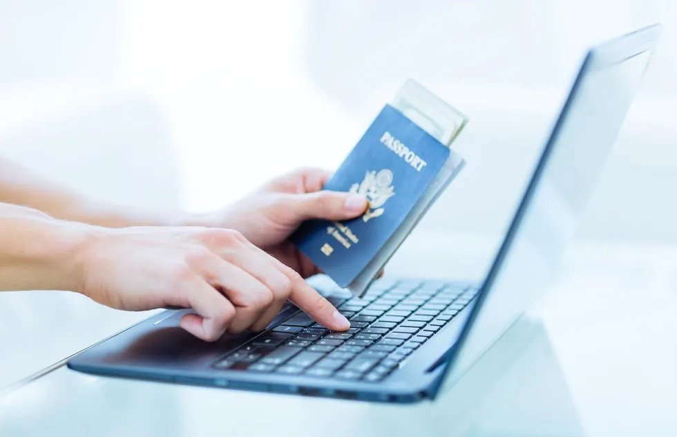 Hands hold U.S. passport at laptop
