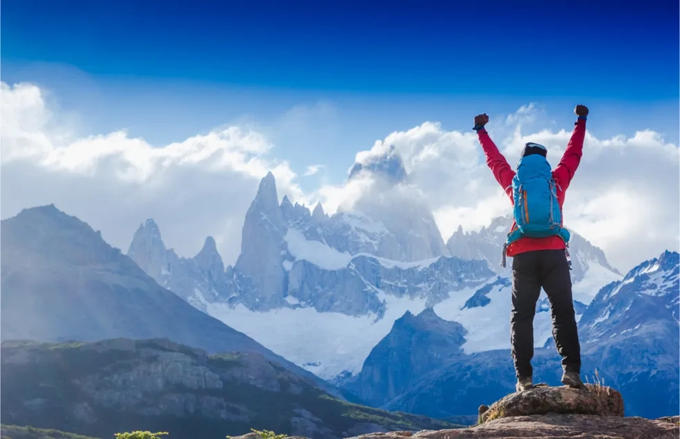 hiker celebrating on summit at Fitz Roy, Argentina (Patagonia)