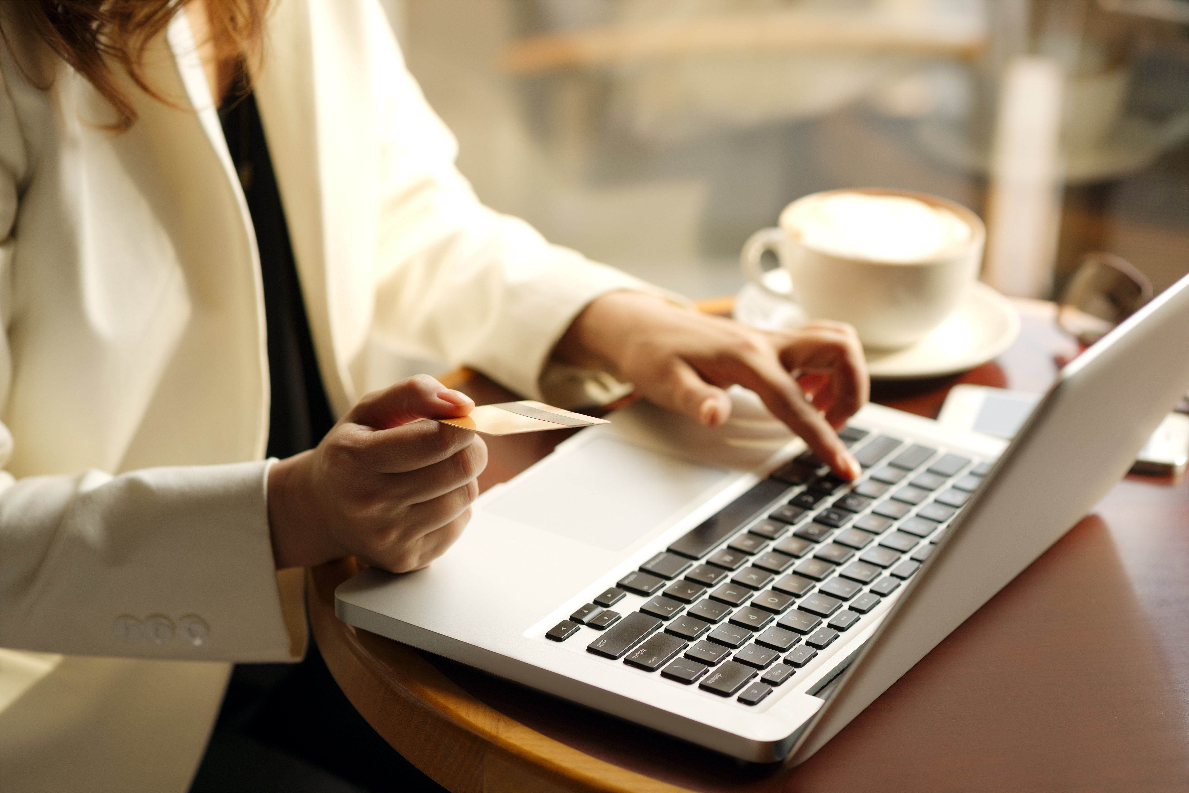 Woman with credit card at open laptop