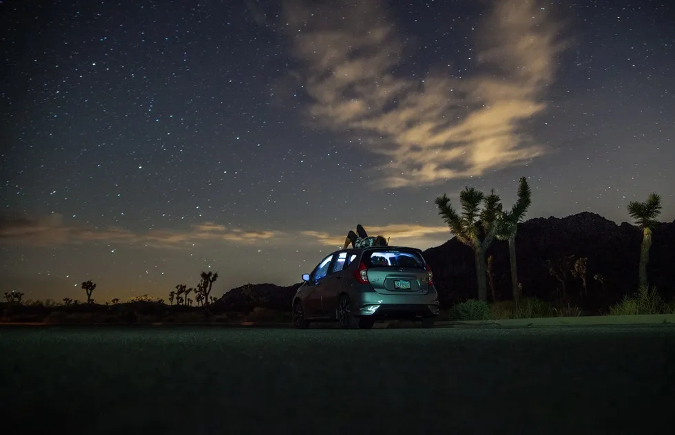 Stargazing on roof of car in desert
