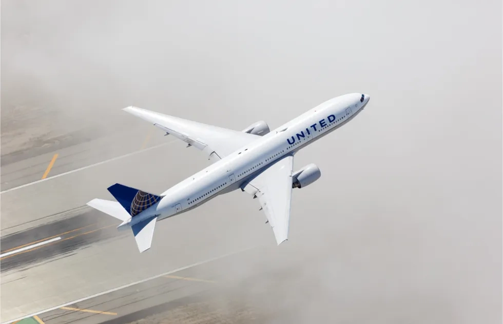 United Airlines jet takes off from runway into a cloud