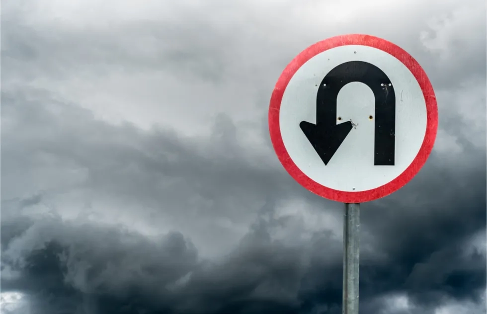 u-turn sign with dark storm clouds